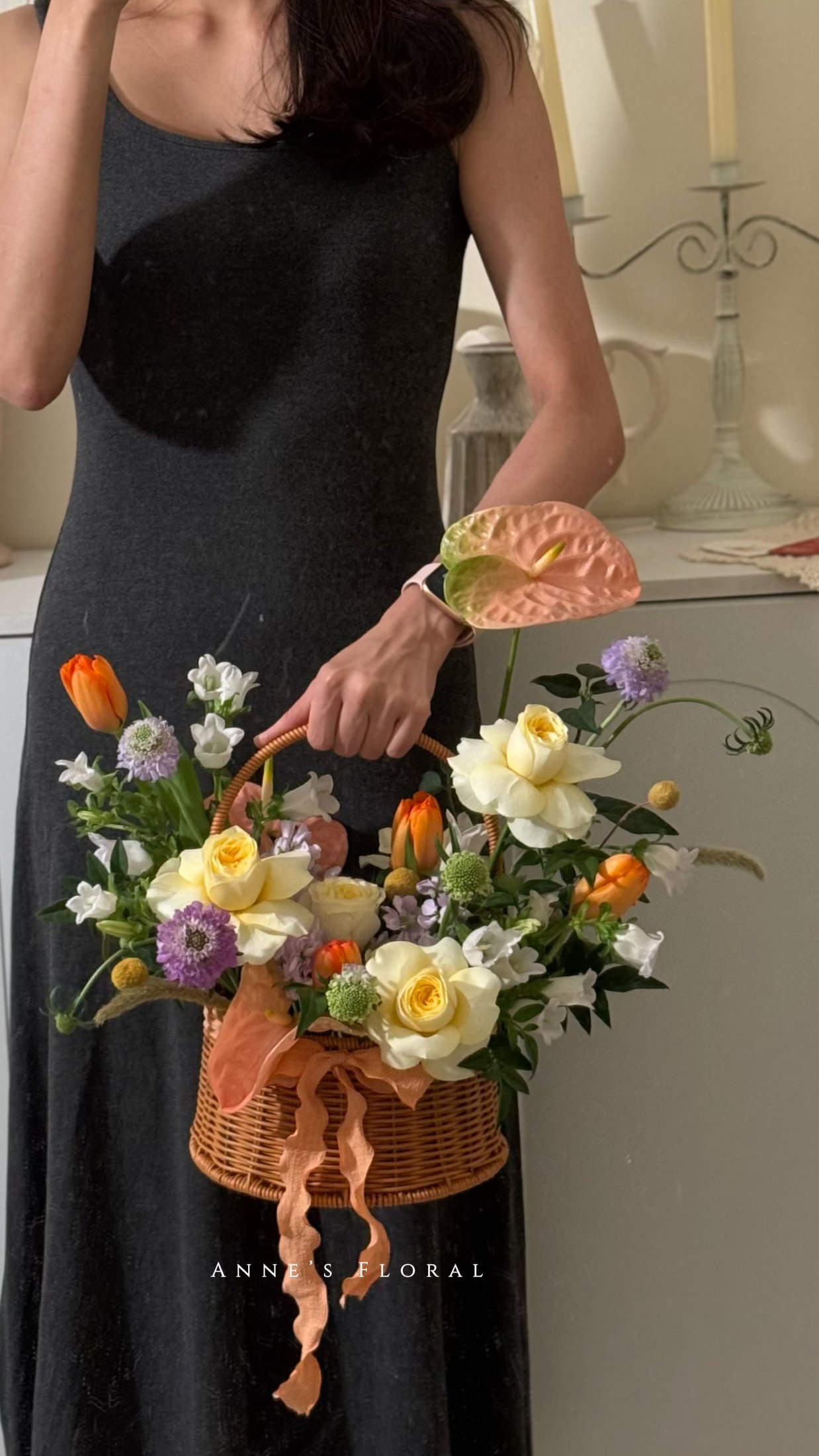 花艺师正在编排一篮橙色、黄色与紫色花艺。